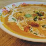 Plating of Paneer Butter masala with fresh cream on top.
